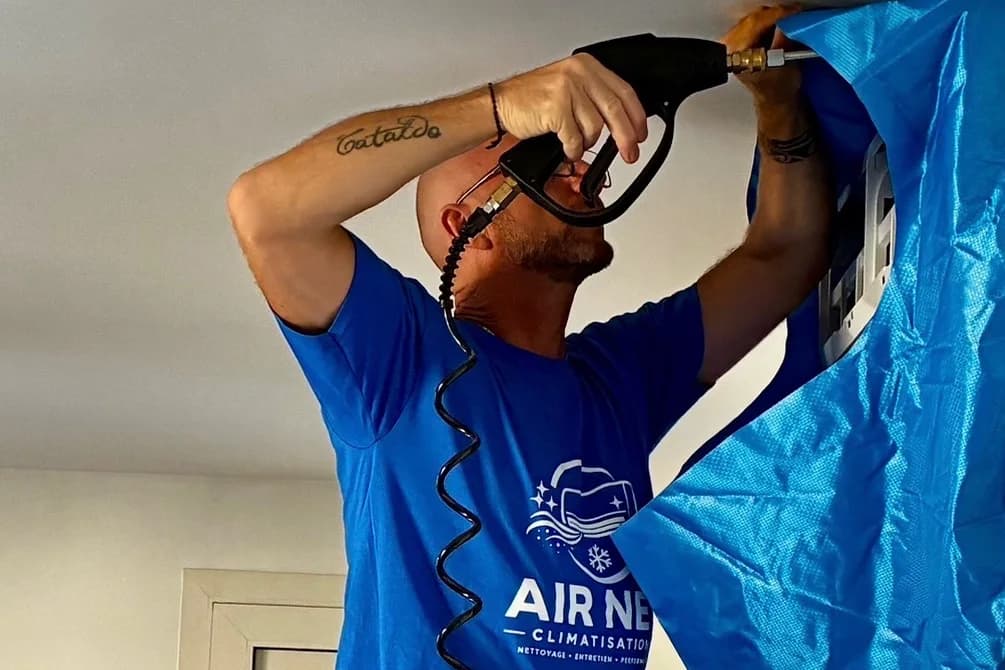 Emmanuel, d'Air Net Climatisation, nettoyant une unité intérieure sous protection étanche